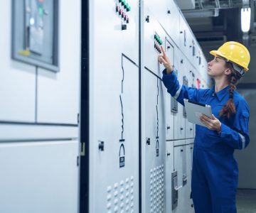 Woman Electrical Engineer working front HVAC control panels, Tec
